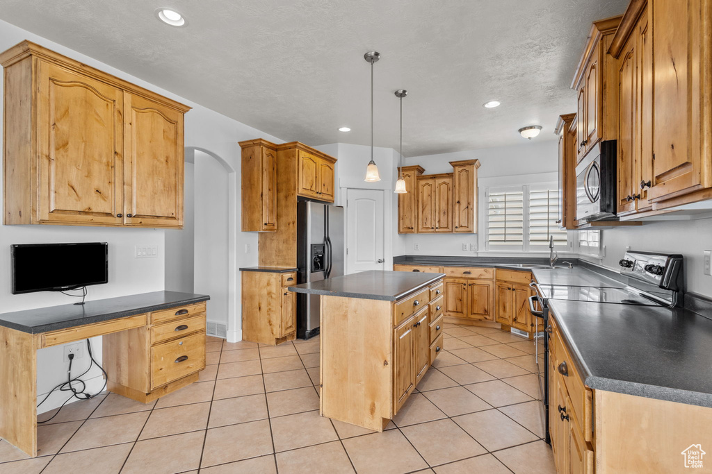 Kitchen with electric range, fridge with ice dispenser, stainless steel microwave, dark countertops, and a center island