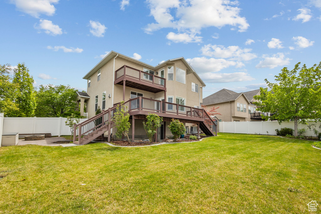 Rear view of house with stairs, a wooden deck, and stucco siding