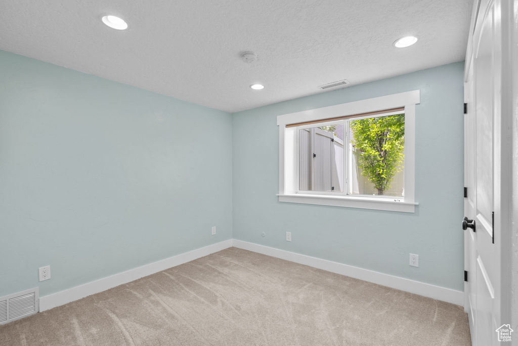 Carpeted empty room with recessed lighting, baseboards, a textured ceiling, and a smoke detector
