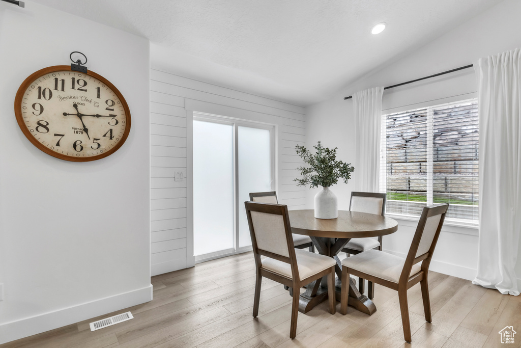 Dining room with light wood-style flooring, lofted ceiling, baseboards, and recessed lighting