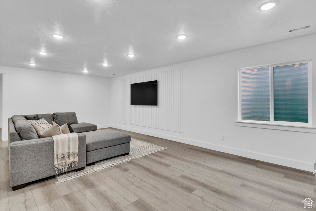 Living room with wood finished floors, recessed lighting, and baseboards