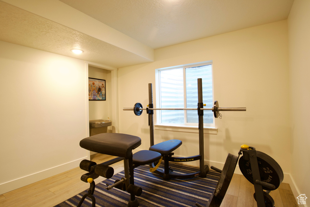 Workout room with wood finished floors and baseboards