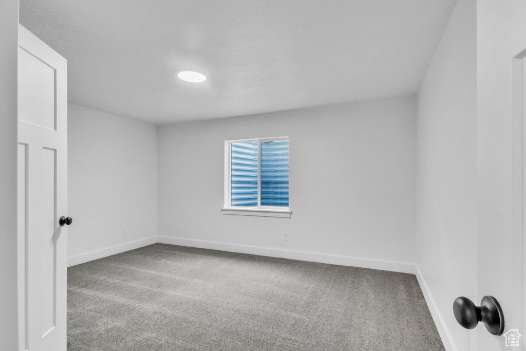 Empty room featuring carpet flooring and baseboards