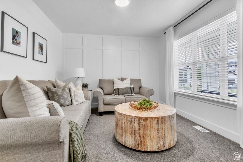 Living room featuring a decorative wall and carpet