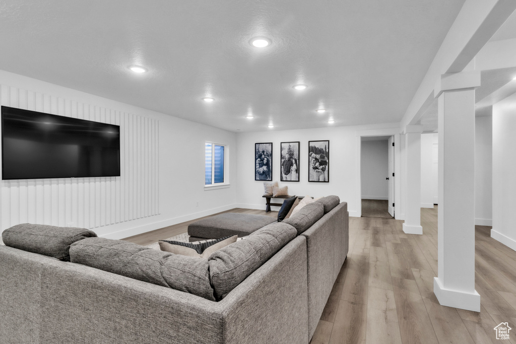Living room featuring light wood-style flooring, baseboards, and recessed lighting