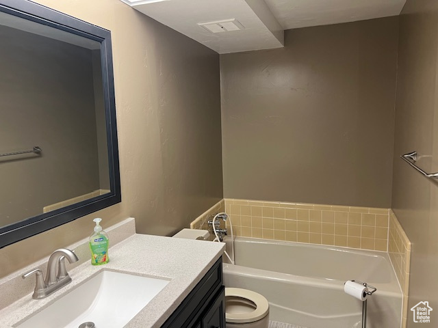 Full bath featuring a garden tub, vanity, and toilet