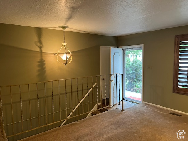 Foyer entrance featuring carpet floors, a textured ceiling, vaulted ceiling, and baseboards