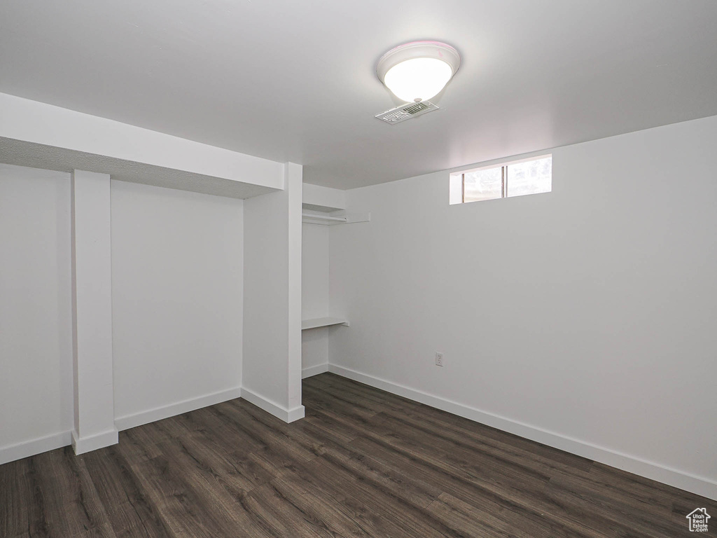 Basement featuring dark wood-type flooring and baseboards