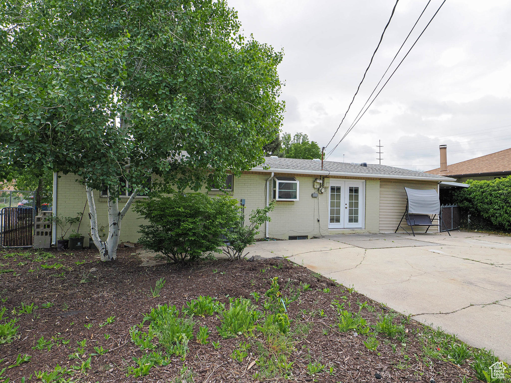 Rear view of property with french doors, brick siding, fence, and a patio
