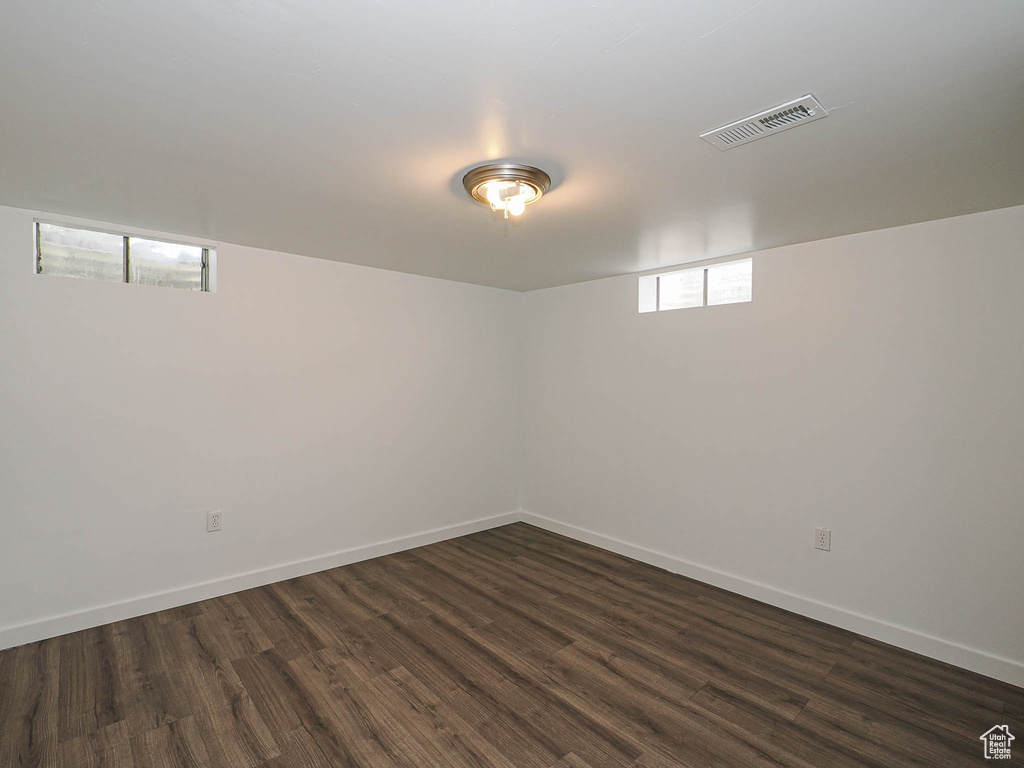 Below grade area featuring dark wood-type flooring and baseboards