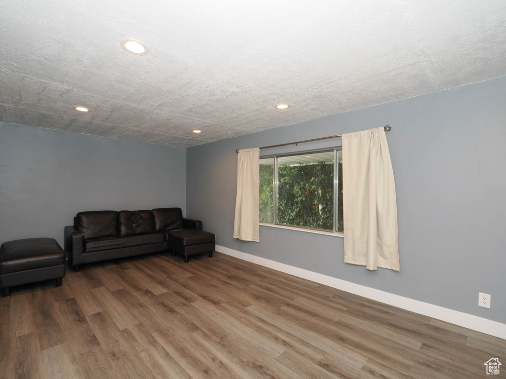 Unfurnished living room featuring wood finished floors, recessed lighting, and baseboards