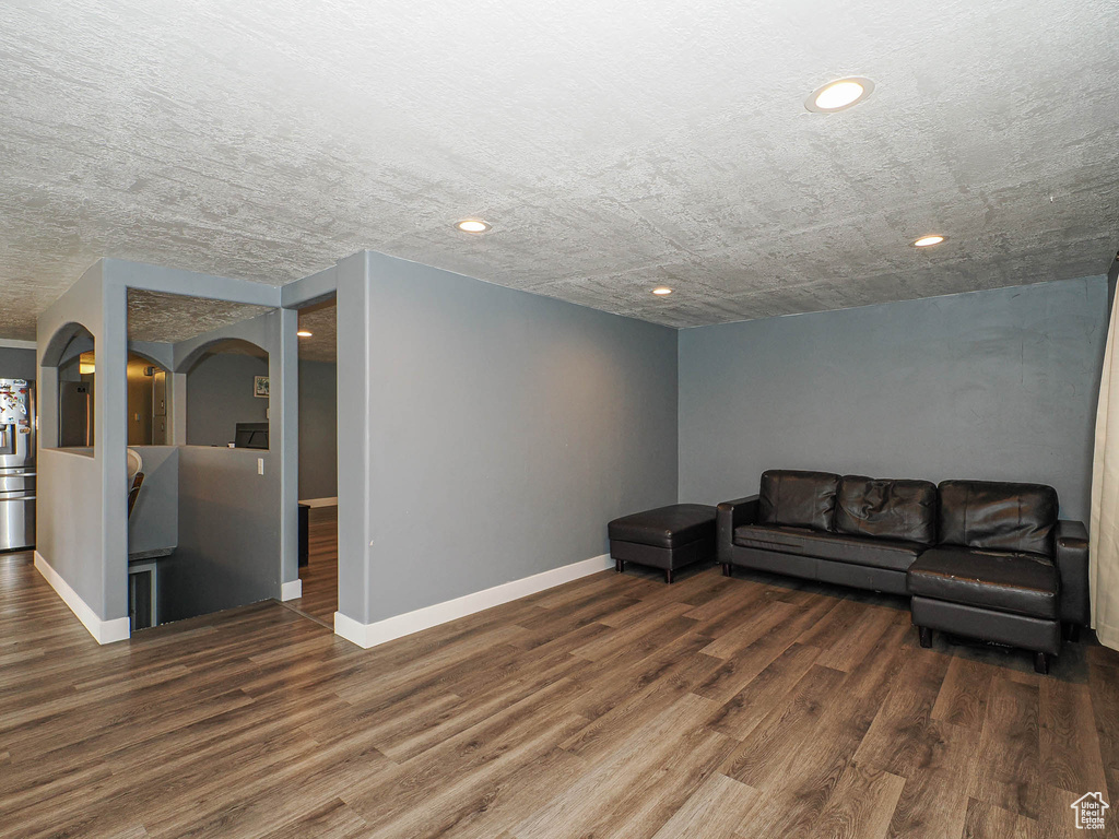 Unfurnished living room featuring wood finished floors, baseboards, and recessed lighting