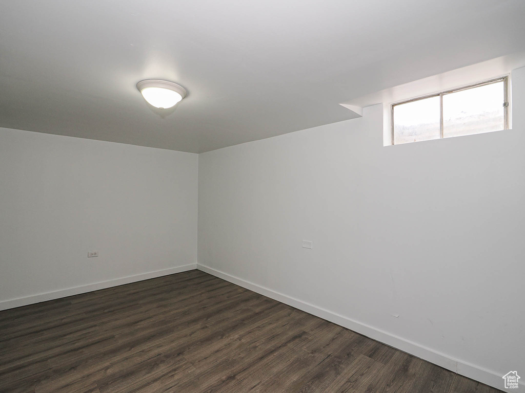 Empty room with dark wood-style flooring and baseboards