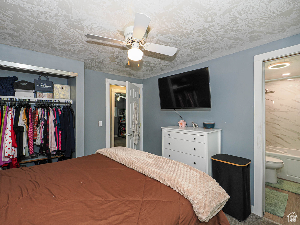 Bedroom with a closet, connected bathroom, and a ceiling fan