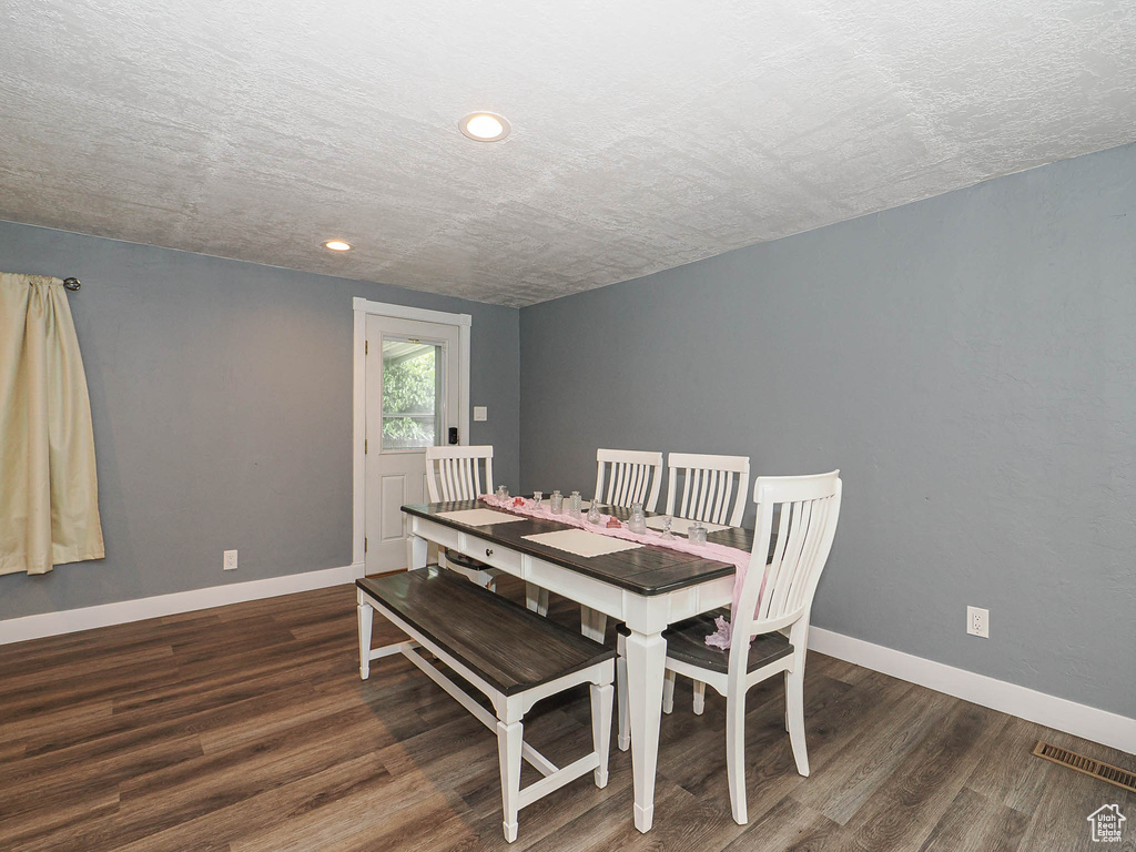 Dining space with wood finished floors, baseboards, recessed lighting, and a textured ceiling