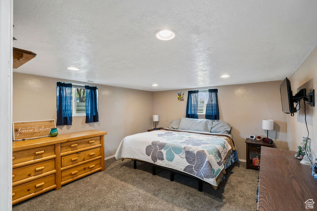 Carpeted bedroom with baseboards, recessed lighting, and a textured ceiling