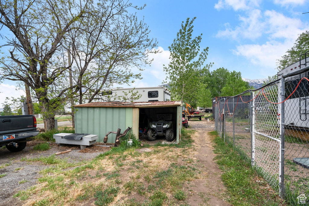 View of yard featuring an outdoor structure and fence