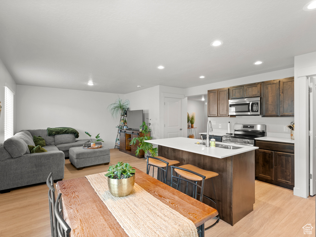 Dining area with light wood finished floors and recessed lighting