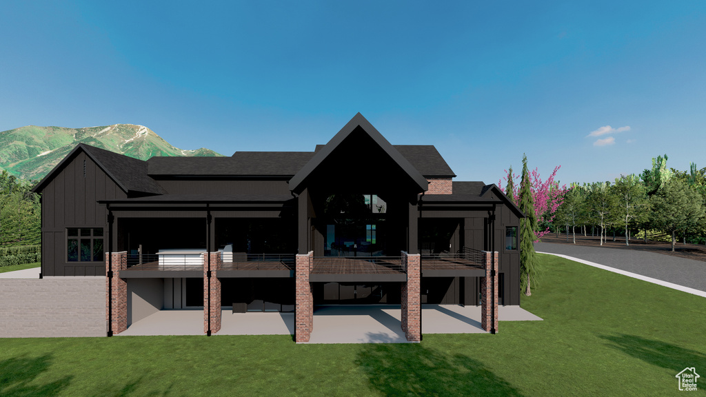 Back of property featuring board and batten siding, a patio area, a lawn, and a balcony