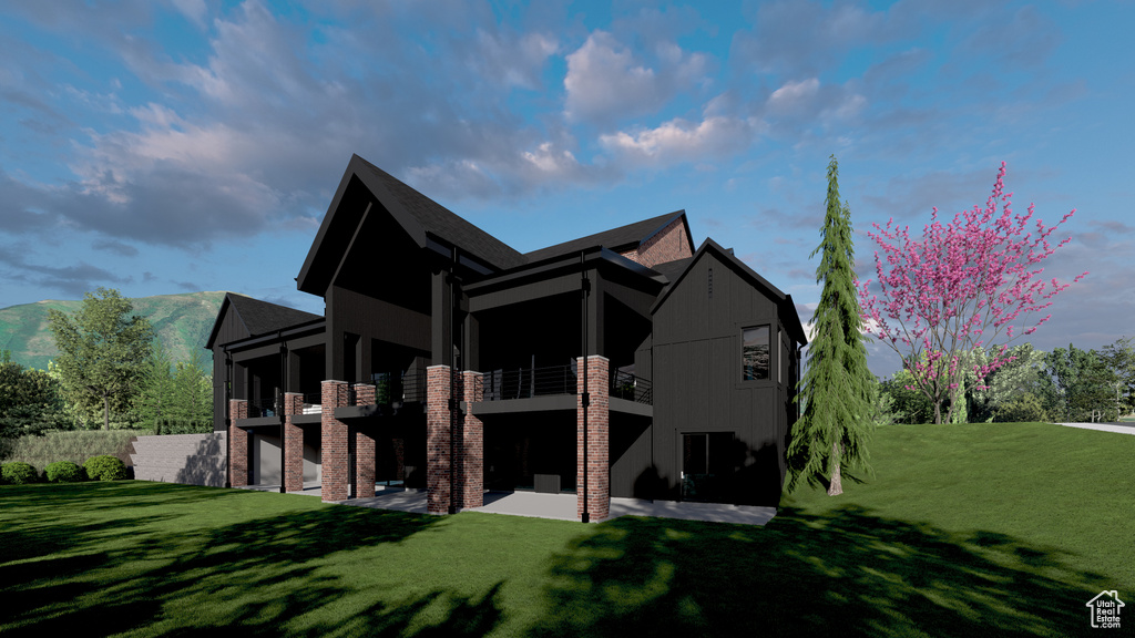 Rear view of house featuring a lawn, a patio area, and a balcony