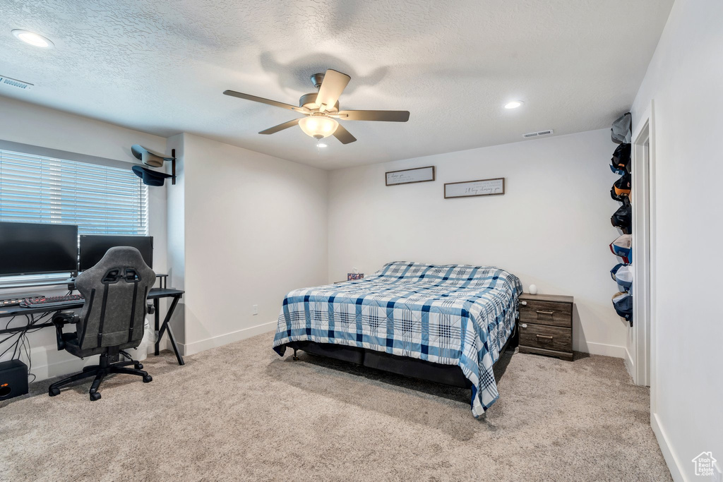 Carpeted bedroom featuring baseboards, ceiling fan, recessed lighting, an office area, and a textured ceiling