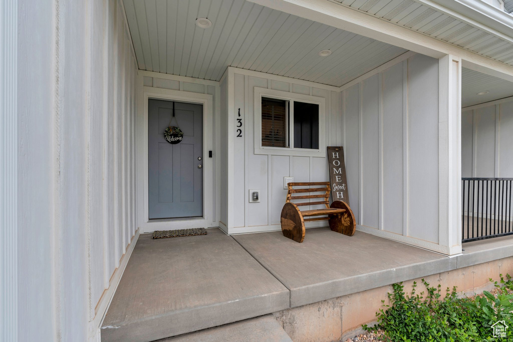 Entrance to property featuring board and batten siding and a porch