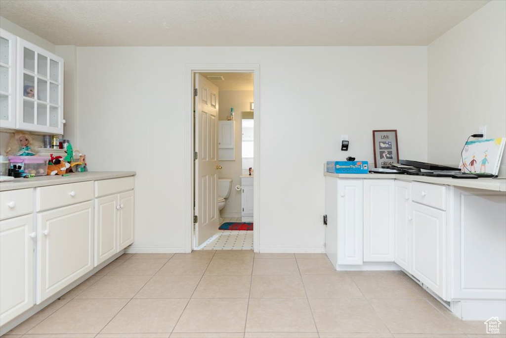 Kitchen featuring light countertops, glass insert cabinets, and white cabinets
