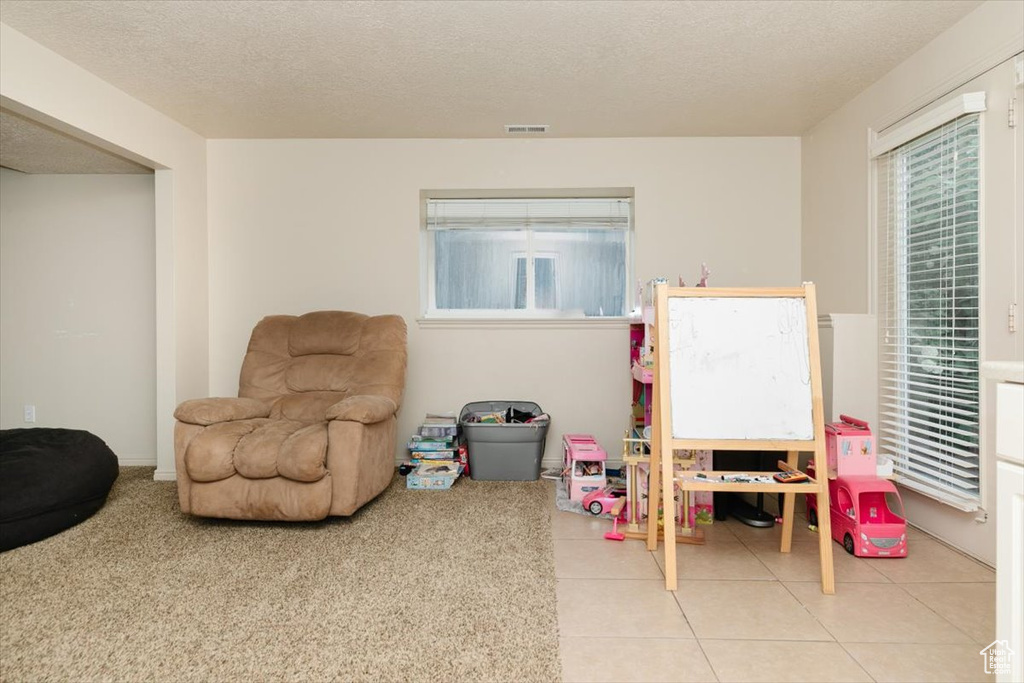 Playroom featuring a textured ceiling and tile patterned flooring