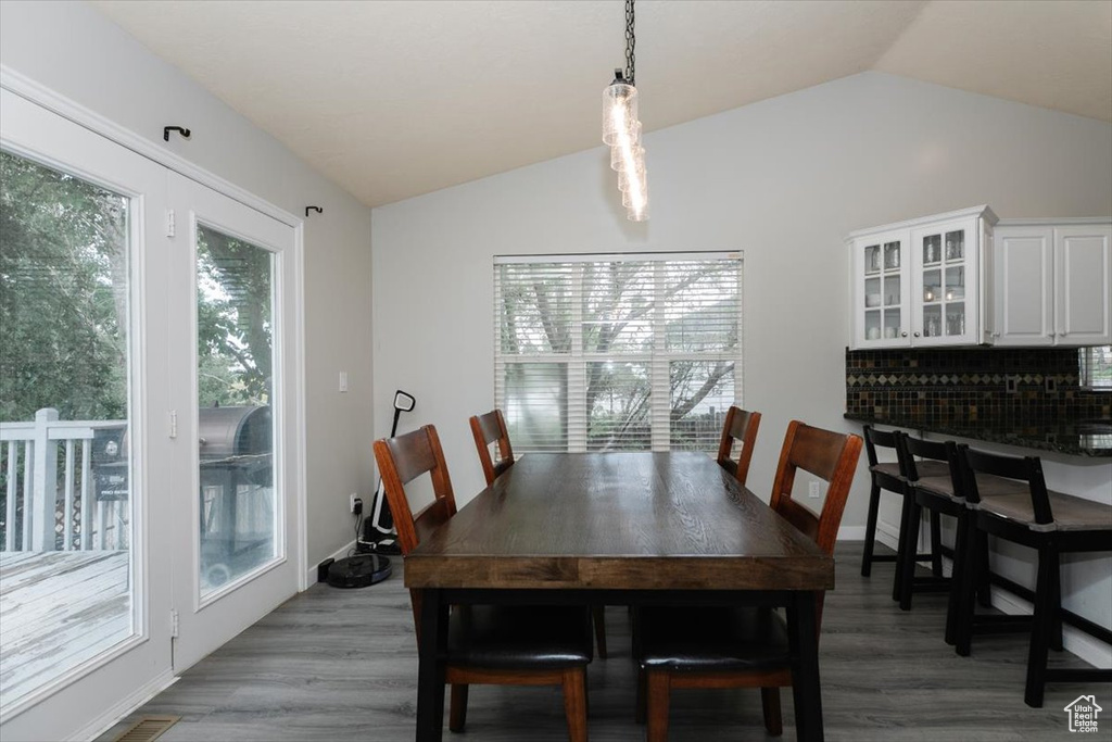 Dining room featuring lofted ceiling and light wood-style floors