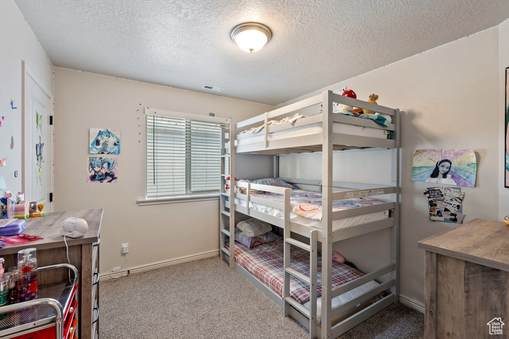 Bedroom featuring carpet flooring, a textured ceiling, and baseboards