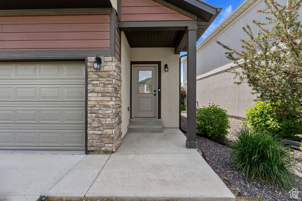 View of exterior entry featuring stone siding and stucco siding