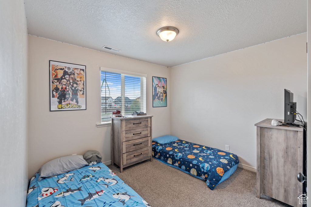 Carpeted bedroom featuring a textured ceiling