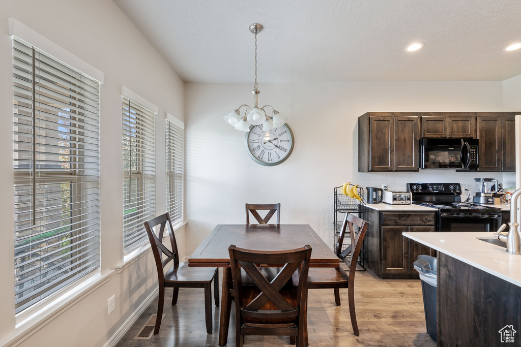 Dining space with a chandelier, light wood finished floors, and recessed lighting