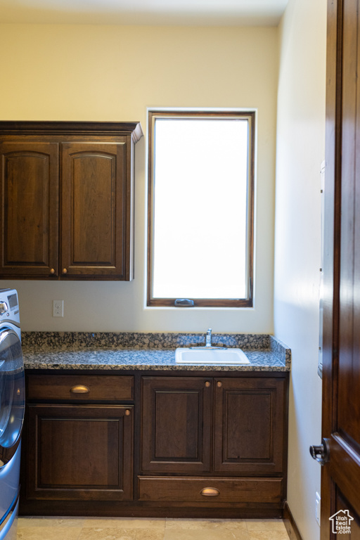 Bathroom featuring a sink and washer / dryer