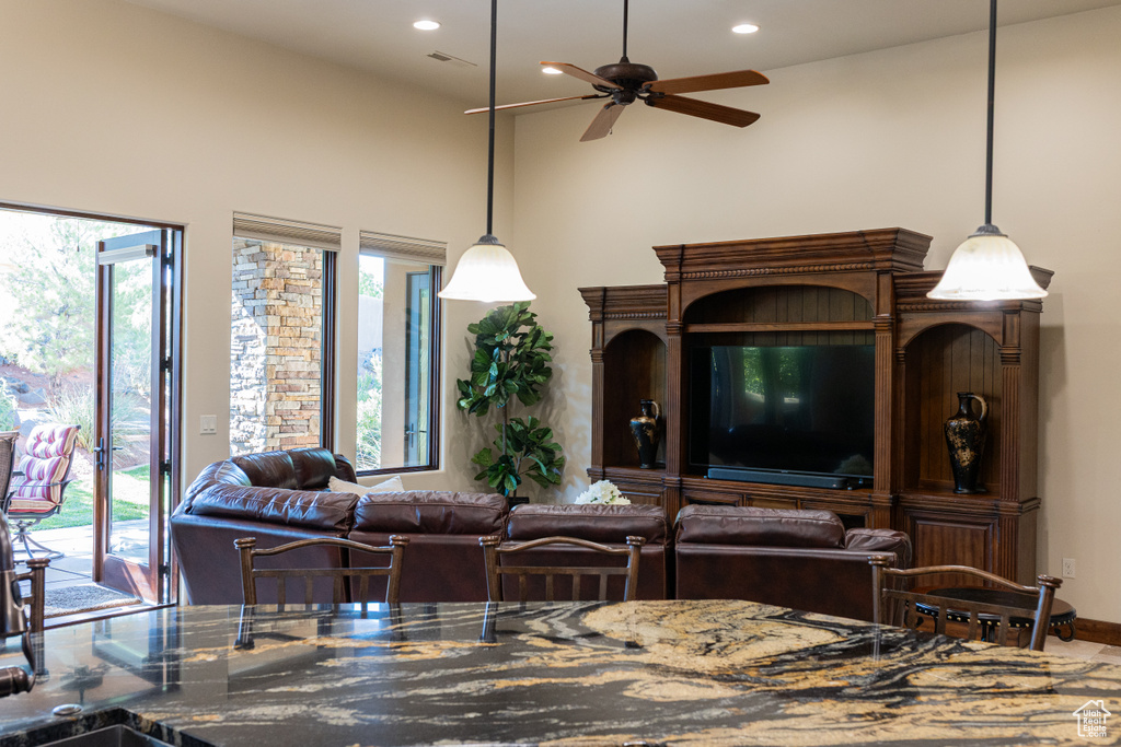 Living room with ceiling fan, recessed lighting, and a high ceiling