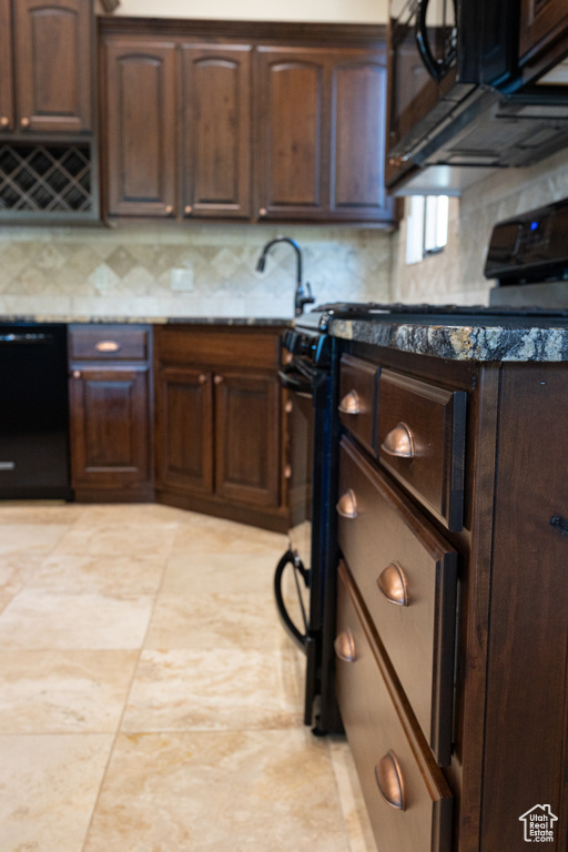 Kitchen featuring black appliances, backsplash, dark brown cabinets, and light stone counters