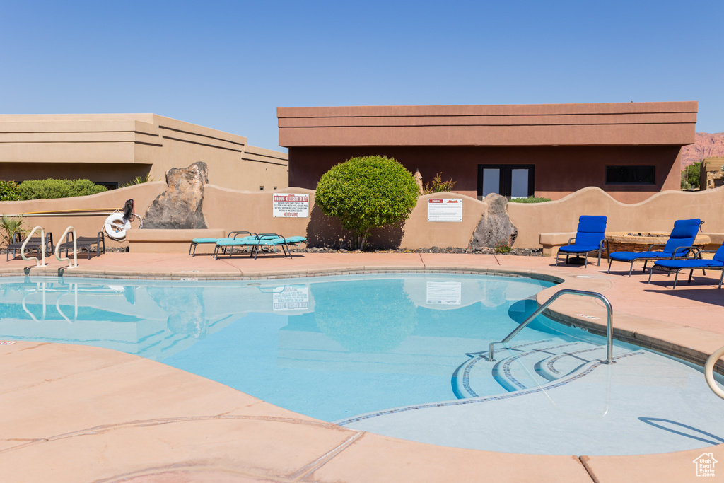 Community pool with a patio and fence