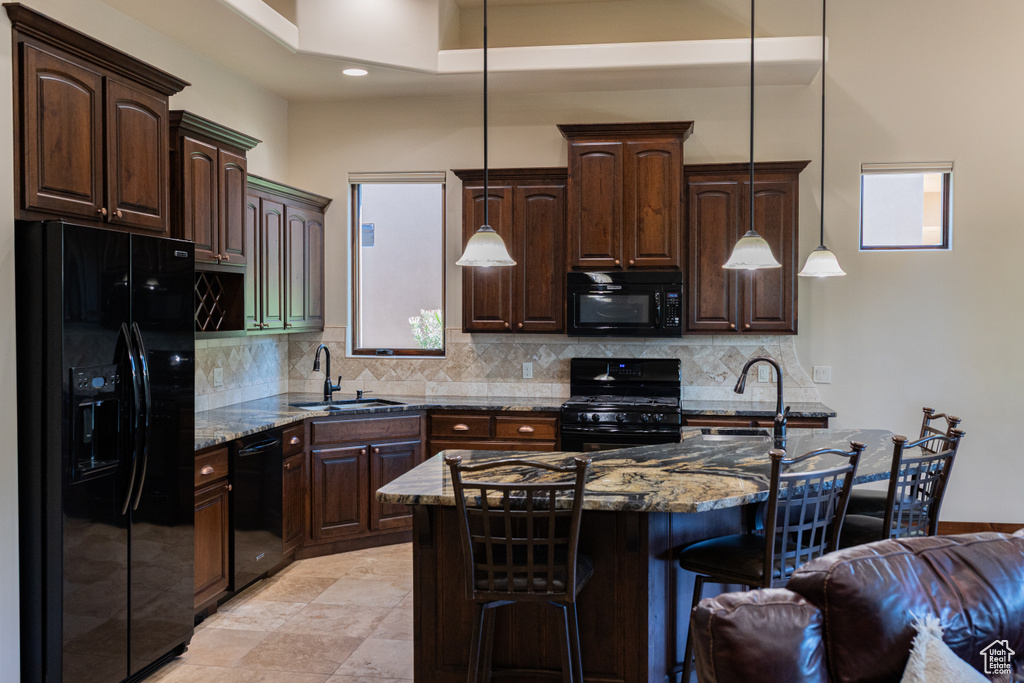 Kitchen featuring black appliances, a sink, dark brown cabinetry, and recessed lighting