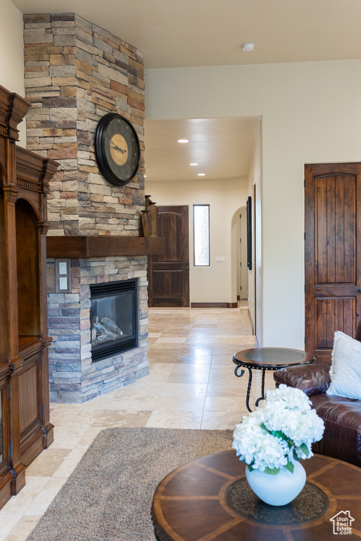 Living area featuring light tile patterned floors, a stone fireplace, recessed lighting, and baseboards