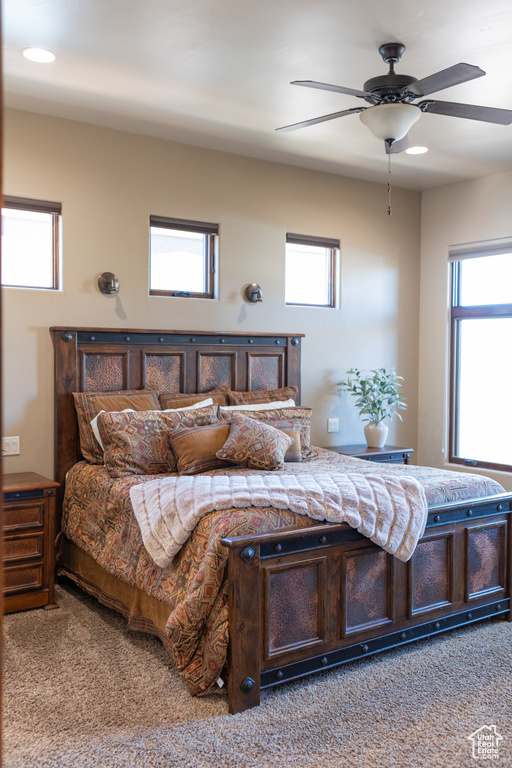 Carpeted bedroom featuring ceiling fan