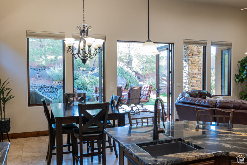 Dining area with a chandelier, a high ceiling, and baseboards