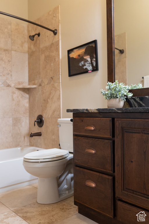Full bath with toilet, tile patterned flooring, vanity, and shower / tub combination