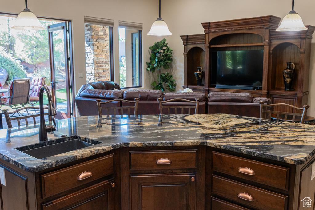 Kitchen with a sink, open floor plan, healthy amount of natural light, and hanging light fixtures