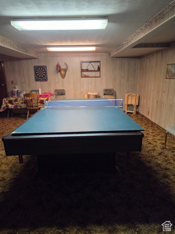 Game room with carpet floors, wood walls, and billiards table