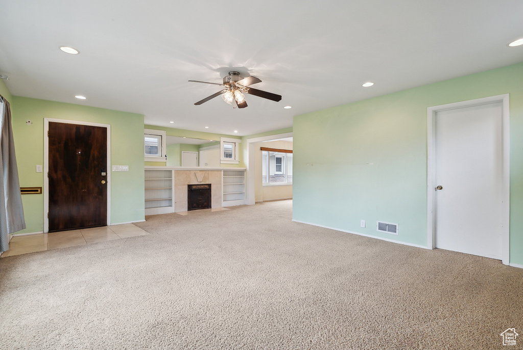 Unfurnished living room with a ceiling fan, light carpet, recessed lighting, a fireplace, and baseboards