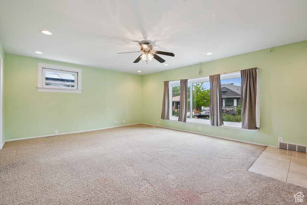 Carpeted empty room featuring ceiling fan, recessed lighting, and baseboards