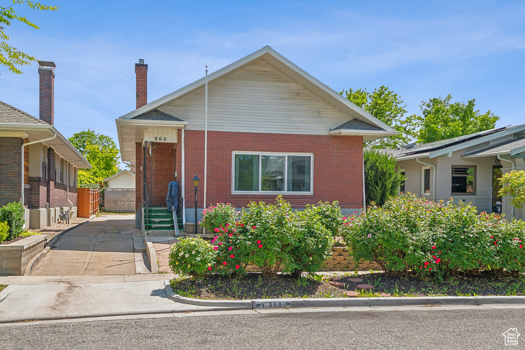 Bungalow-style home with brick siding and fence