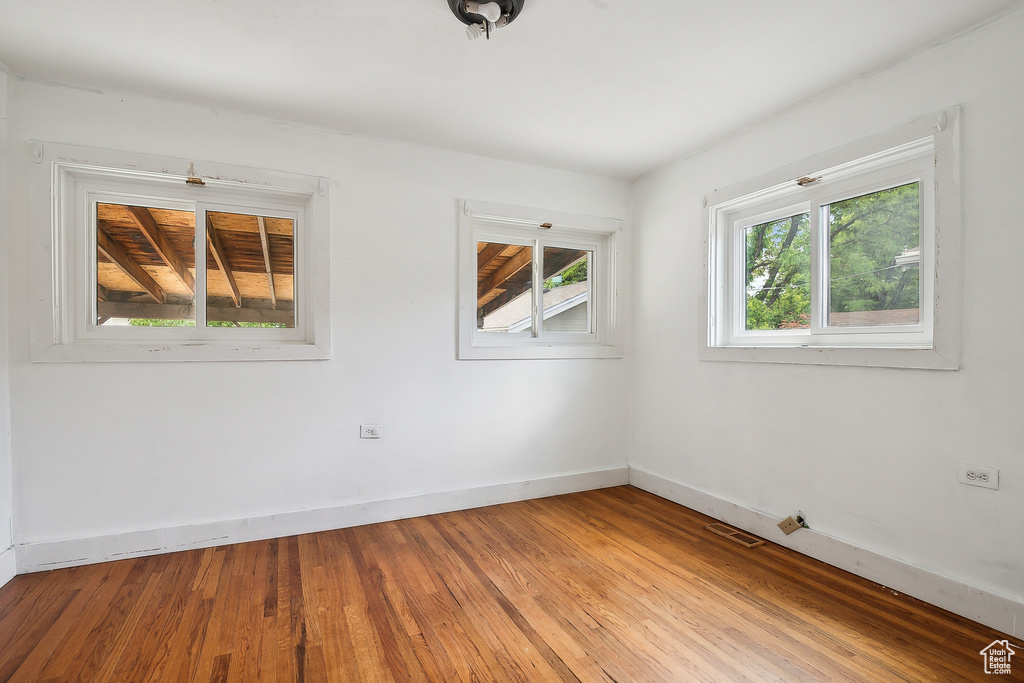 Spare room with baseboards and wood finished floors