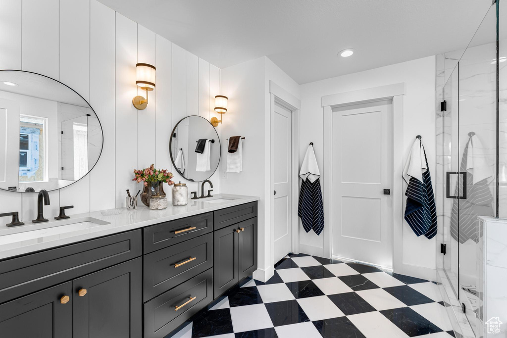 Bathroom featuring tile patterned floors, a shower stall, double vanity, and recessed lighting