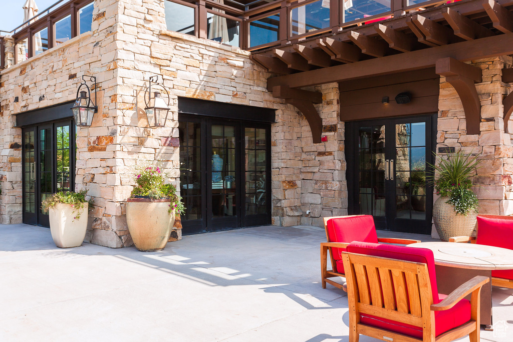 View of patio with french doors and a balcony